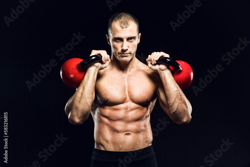 Muscular man with the kettlebells