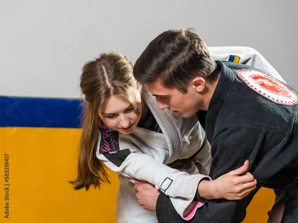 Obraz premium Young girl and boy practice Brazilian jiu jitsu in the gym