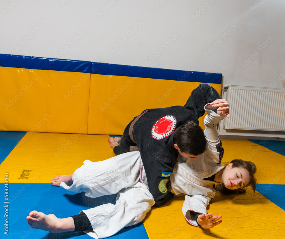 Young girl and boy practice Brazilian jiu jitsu in the gym Young girl and boy practice Brazilian jiu jitsu in the gym