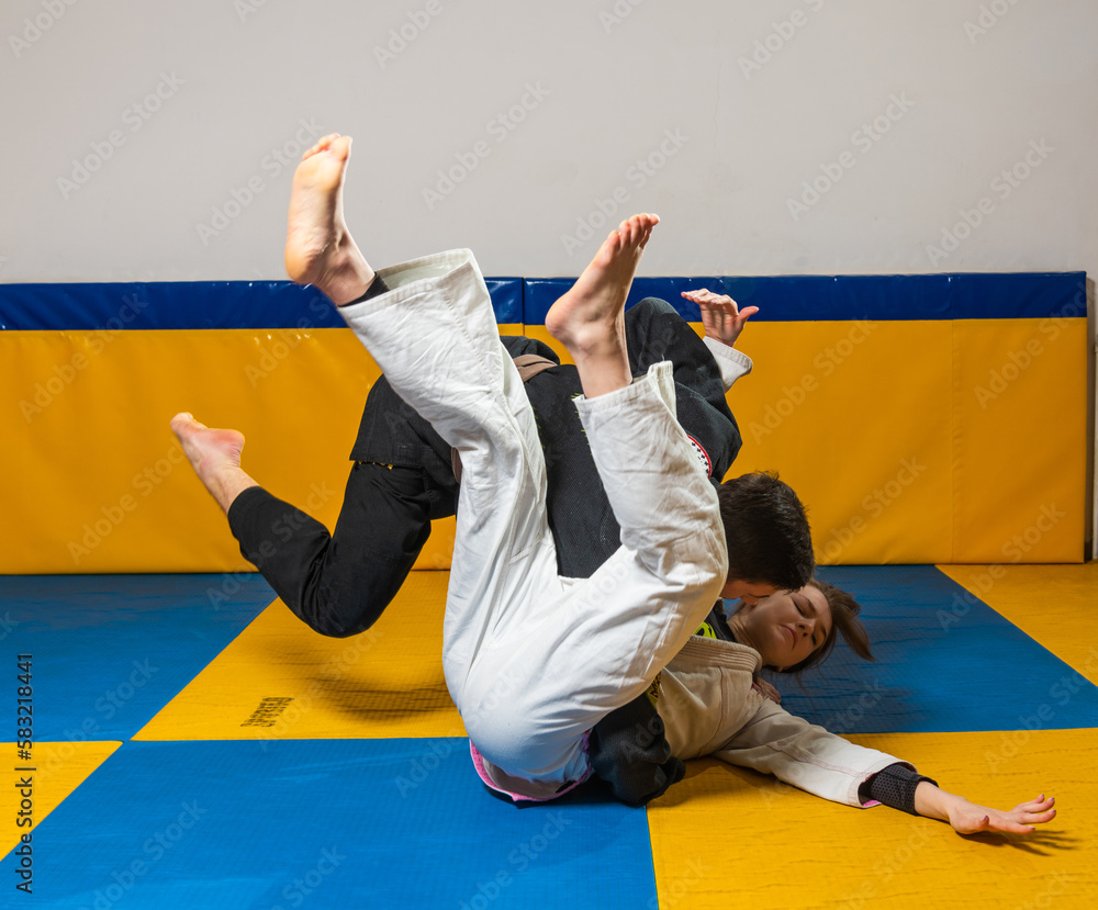 Young girl and boy practice Brazilian jiu jitsu in the gym Young girl and boy practice Brazilian jiu jitsu in the gym