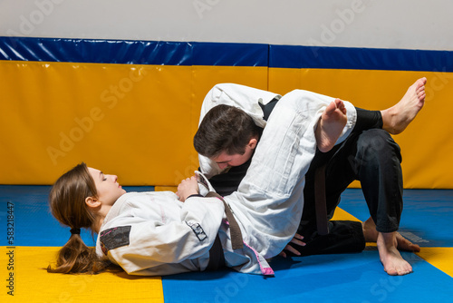 Young girl and boy practice Brazilian jiu jitsu in the gym © Дмитро Петрина