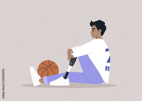 A young male Caucasian  basketball player with a prosthetic leg sitting on a floor
