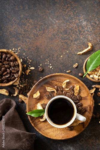 Healthy organic energizing adaptogen. Mushroom coffee in a cup and coffee beans, trendy drink on a stone background. Copy space. View from above. Copy space.