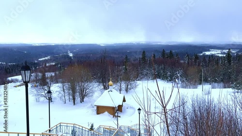 View of the chapel near the Belogorsky St. Nicholas Orthodox Missionary Monastery. Winter forest. The temple on the hill in winter. Russia, Perm Krai, Belaya Gora. 4K photo