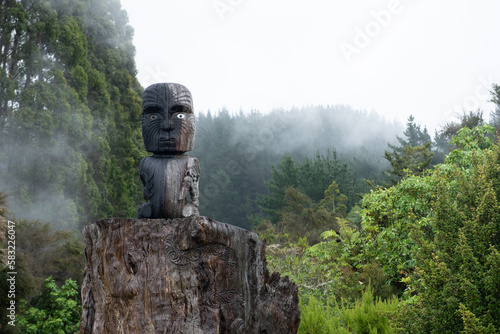 Maori tiki statue surrounded by mist in Waikato Aotearoa New Zealand in nature
