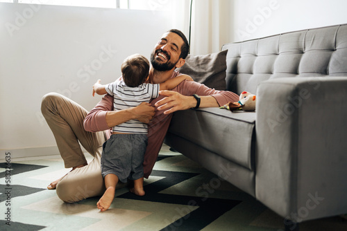 Obraz na plátně Happy father hugging little son at home