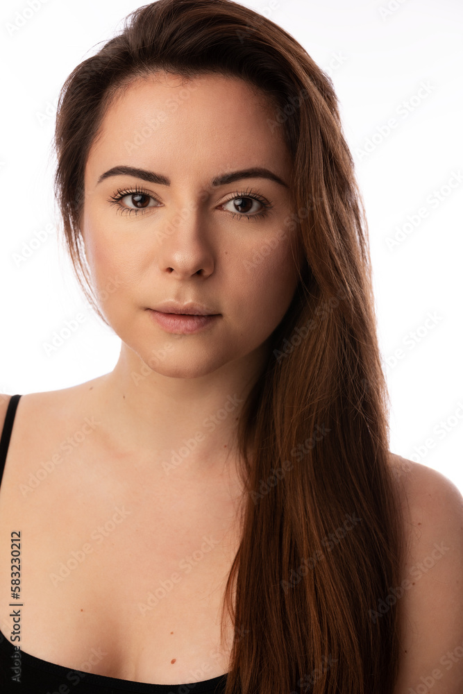 Studio portrait of a beautiful Ukrainian model in her 20s. She has brown hair and eyes. She is wearing a black tank top.