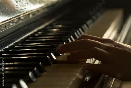 girl playing old vintage piano, close up hands. cinematic, dark key