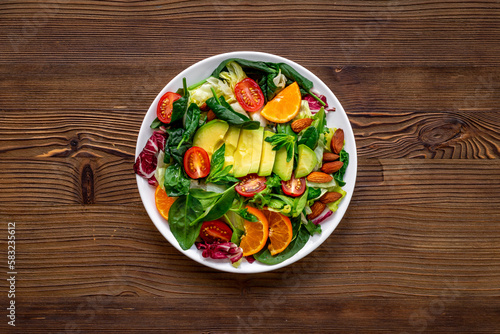 Healthy vegetarian bowl - green salad with avocado and tomatoes