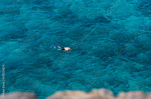 Top view of snorkeler swimming scuba diving in tropical sea ocean