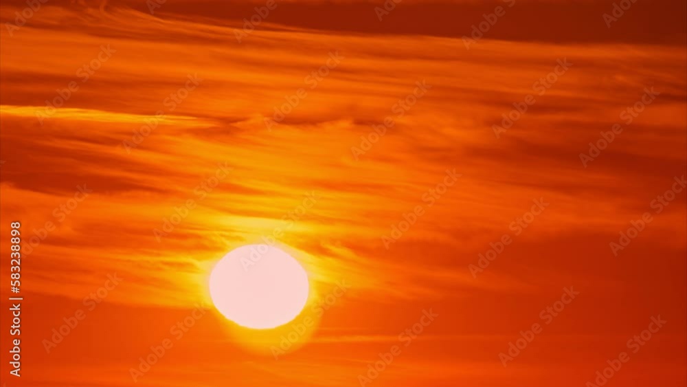 Evening red sun in the clouds at sunset sets over the horizon, timelapse Evening red sun in the clouds at sunset sets over the horizon, timelapse