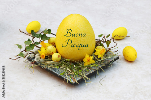 Cartolina d'auguri di buona Pasqua: nido di Pasqua con uova di Pasqua gialle e un uovo di Pasqua con lettere. photo