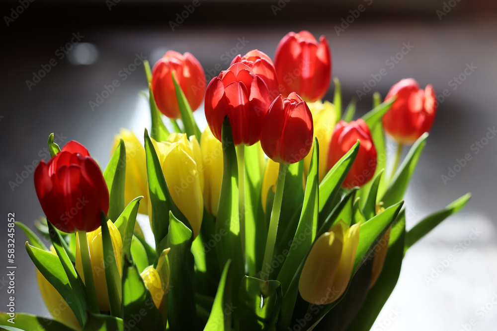 Naklejka premium Bukiet czerwonych tulipany w szklanym wazonie.