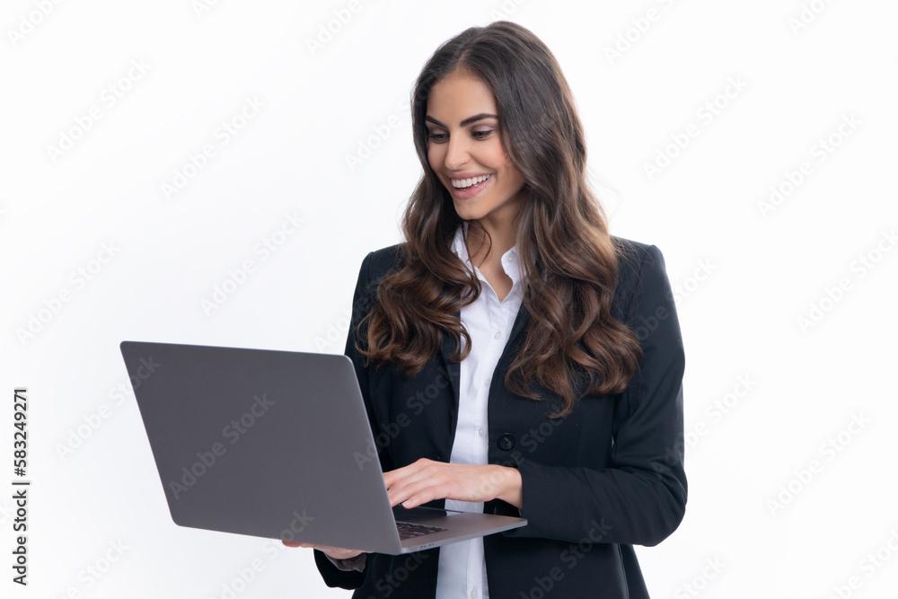 Cheerful business woman standing over grey wall with laptop computer. Portrait of pretty, charming, stylish, clever woman with open laptop chatting, using internet, isolated on grey background. Cheerful business woman standing over grey wall with laptop computer. Portrait of pretty, charming, stylish, clever woman with open laptop chatting, using internet, isolated on grey background.