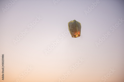 Chinese, paper, yellow lantern in the blue sky at sunset. Making wishes. Earth pollution.