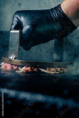 Tableau sur toile hand of a man smashing an oklahoma burger