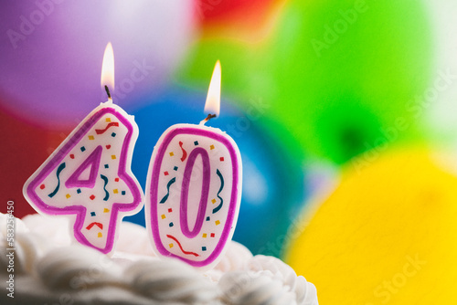 Number 40 Birthday Candles Against Colorful Balloon Background photo