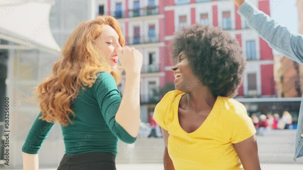 Happy friends multicultural dancing together in the street Happy friends multicultural dancing together in the street