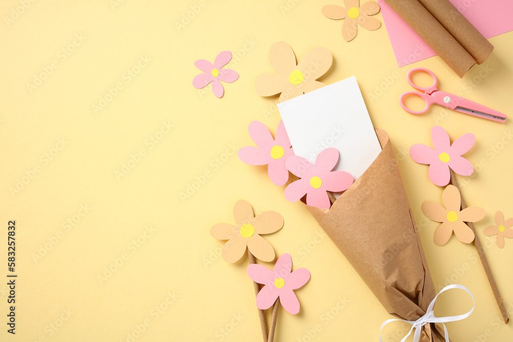 Bouquet of paper flowers handmade by child from colorful paper on pastel yellow background