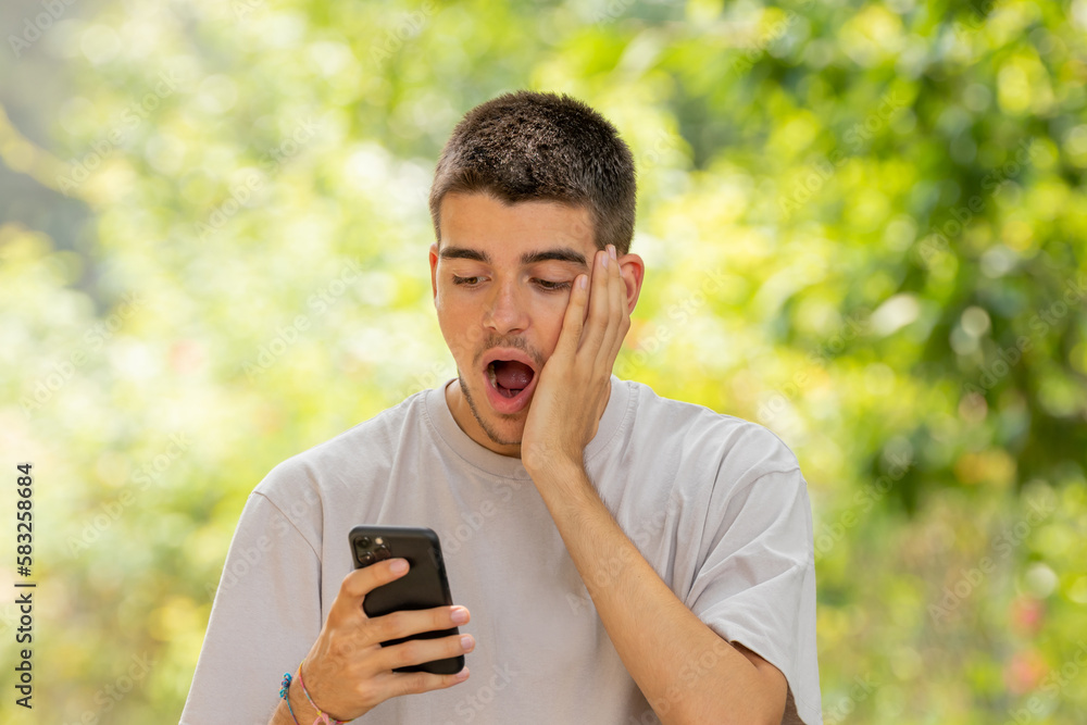 surprised young man looking at mobile phone surprised young man looking at mobile phone