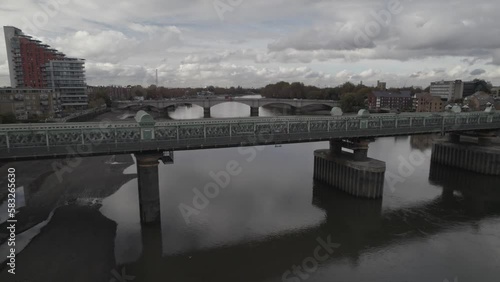 Calm water surface reflecting Fulham Railway and Putney Bridge photo