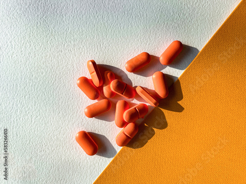 red Orange pills on a white and yellow background	