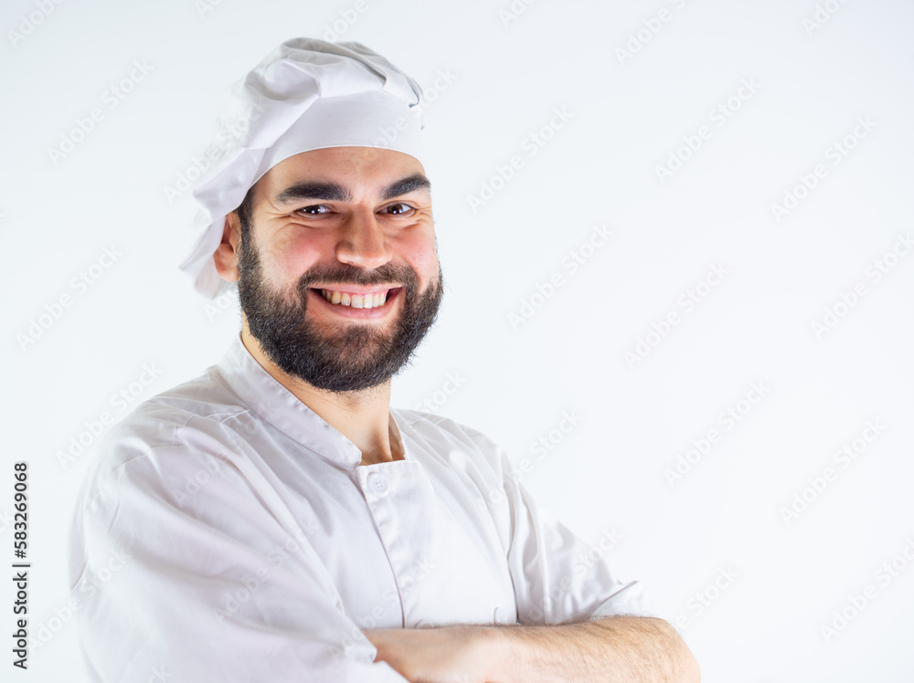 Young male chef portrait with arms crossed while smiling and looking at camera. Isolated on a white background Young male chef portrait with arms crossed while smiling and looking at camera. Isolated on a white background