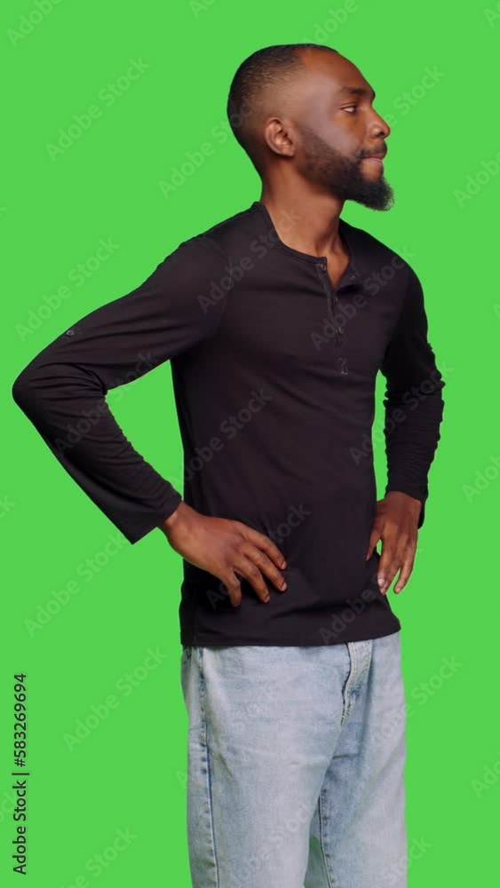 Vertical video: Side view of male model feeling pensive thinking about information on isolated green screen backdrop, being thoughtful and waiting. Young man with patience brainstorming new ideas in Vertical video: Side view of male model feeling pensive thinking about information on isolated green screen backdrop, being thoughtful and waiting. Young man with patience brainstorming new ideas in