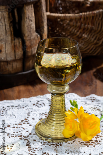 Antique German glassware, old Dutch style rummer or roemer glasses with white wine on white lace tablecloth photo