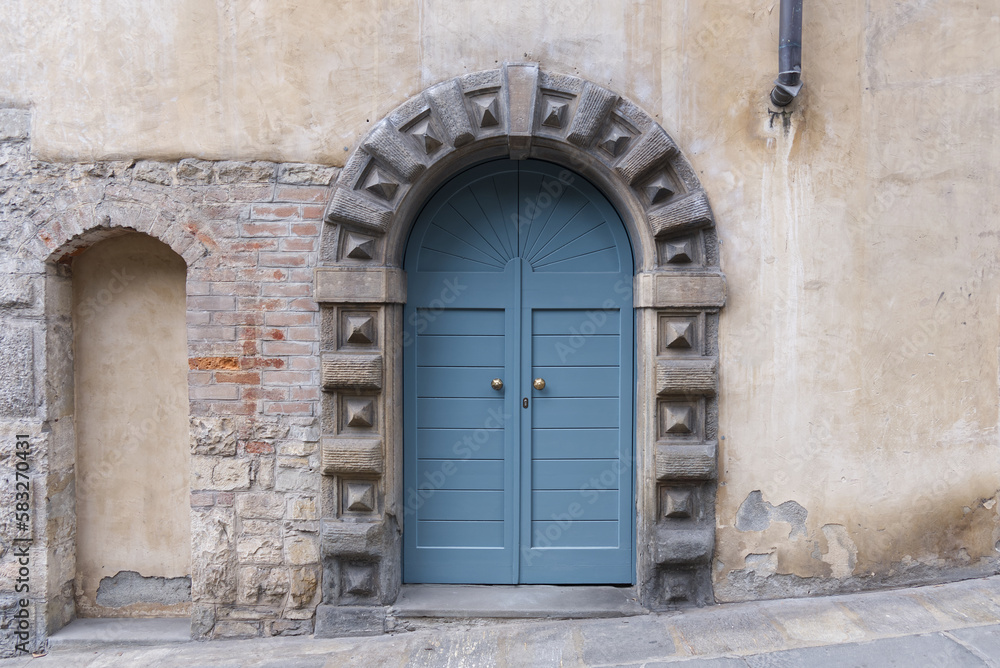 a modern blue front door with a traditional stone border in an italian house