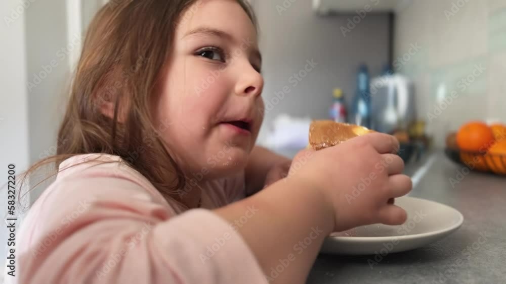 A beautiful little girl with an appetite eats homemade cake on a sunny morning in the kitchen. The concept of a happy childhood, homemade cakes A beautiful little girl with an appetite eats homemade cake on a sunny morning in the kitchen. The concept of a happy childhood, homemade cakes