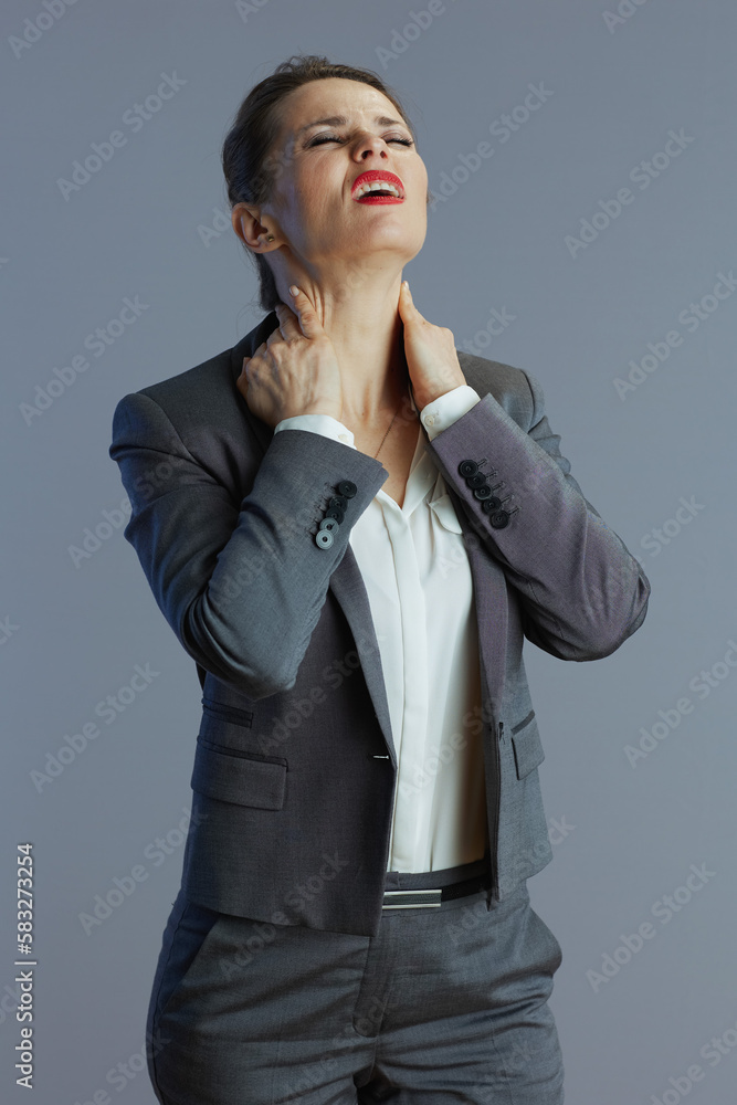 stressed business owner woman having neckpain against grey stressed business owner woman having neckpain against grey