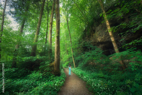 Beautifl old green forest and young woman on the trail in summer photo