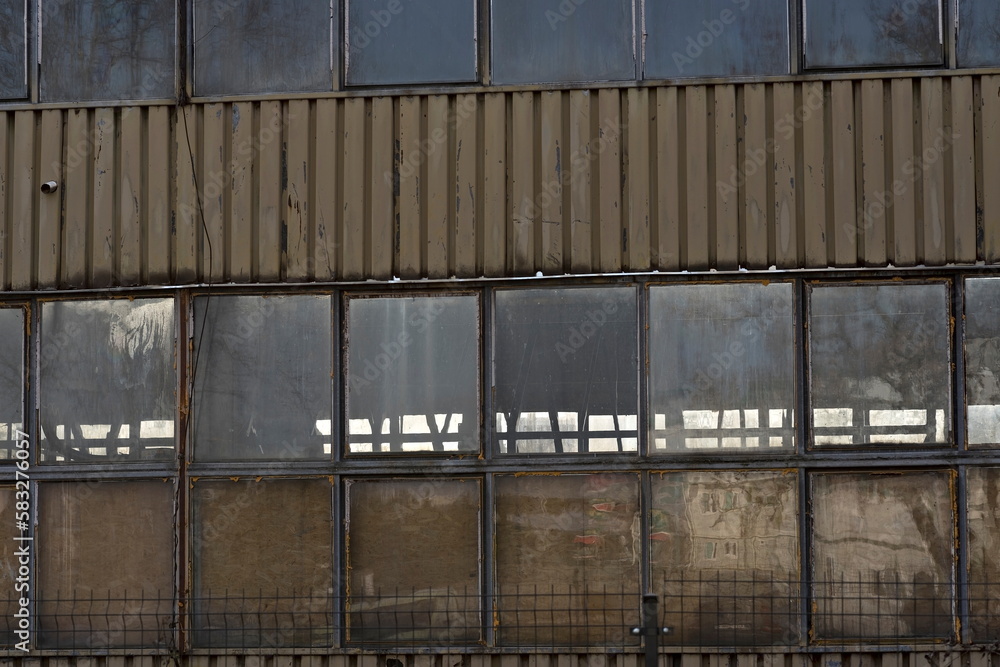 Stara hala przemysłowa ze scianami z blachy falistej i z dużymi oknami . Hala obecnie też wykozystywana do produkcji . Strefa przemysłowa w mieście . - obrazy, fototapety, plakaty 