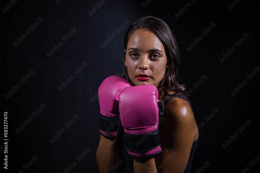 Dark Haired Girl Boxing a Punching Bag in a Moody Setting