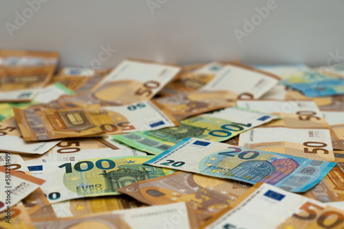 Euro banknotes scattered on the table. Focus in the foreground.