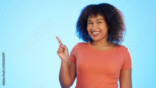 Mockup, advertising and woman pointing at deal, sale or copy space isolated in a studio blue background with smile. Portrait, young and exited female or happy customer choice and showing empty space