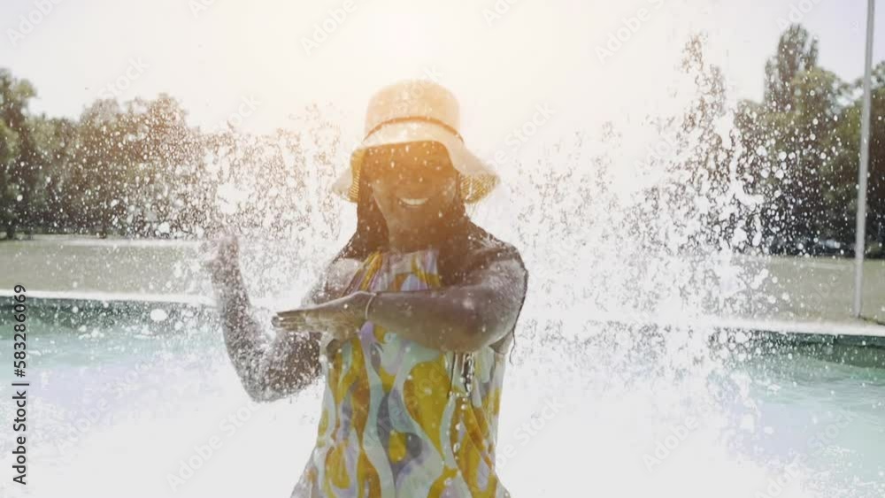 Carefree Young Woman Standing in water fountain chilling Carefree Young Woman Standing in water fountain chilling
