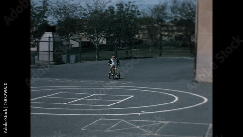 Riding Trike Playground 1968 - A three years old boy rides his trike in the school playground
