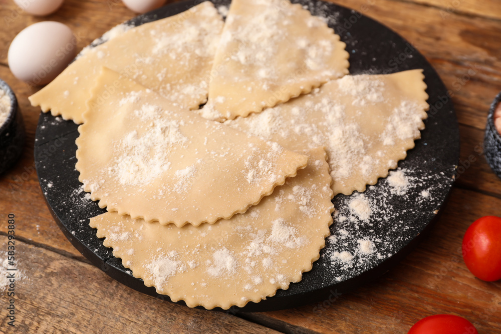 Board with raw meat empanadas on wooden background, closeup Board with raw meat empanadas on wooden background, closeup