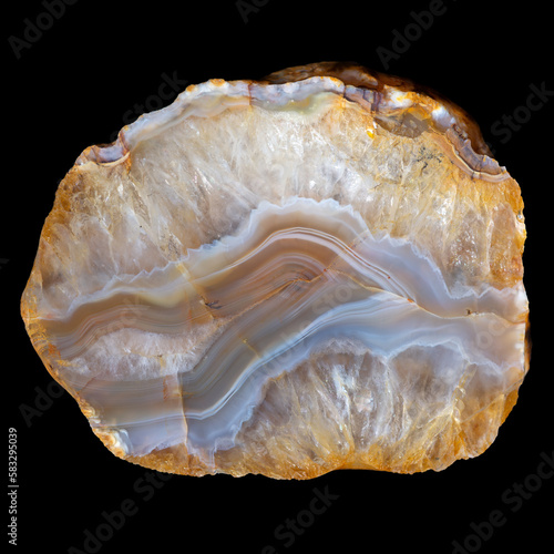 Yellow-blue layered agate with crystalline quartz isolated on a black background