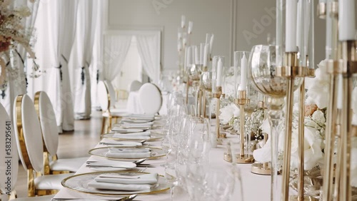 Crockery glasses flowers arrangement and candles on table