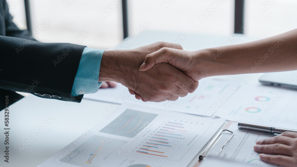 Shaking hands, Auditor and the company's bookkeeper jointly review the balance sheet and assets, liabilities and equity information in the quarterly report, bookkeeping concept. Shaking hands, Auditor and the company's bookkeeper jointly review the balance sheet and assets, liabilities and equity information in the quarterly report, bookkeeping concept.