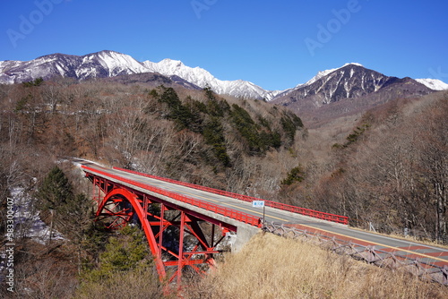 残雪の八ヶ岳と赤い橋（東沢橋）