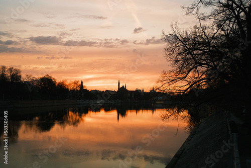 Obraz na płótnie Sunset over the river. Dramatic clouds on the sky and trees in the front. Wrocław, Poland w salonie