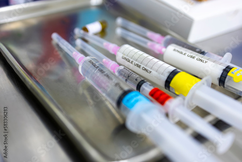 Obraz na plátně A medical syringe with a colorful tag label on stainless tray in hospital