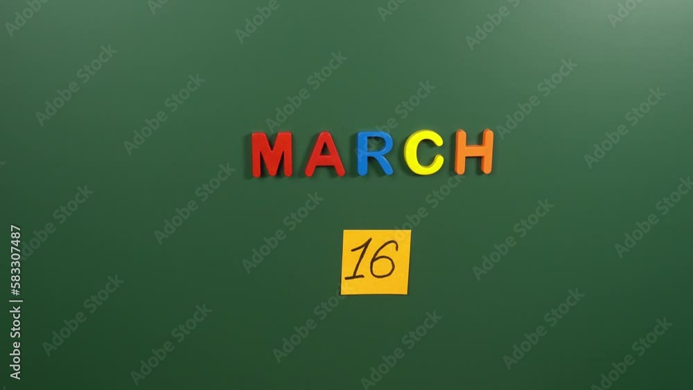 Hand sticking a sticker 16 March calendar day on school board. 16 date of March. Sixteenth day of March. 16th date number. 16 day calendar. Sixteen date Hand sticking a sticker 16 March calendar day on school board. 16 date of March. Sixteenth day of March. 16th date number. 16 day calendar. Sixteen date