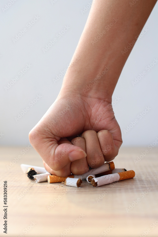 Hand fist smash or punch on cigarette. Smoking reduction campaign in