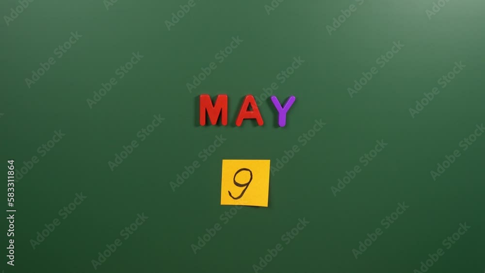 Hand sticking a sticker 9 May calendar day on school board. 9 date of May. Ninth day of May. 9th date number. 9 day calendar. Nine date. Europe Hand sticking a sticker 9 May calendar day on school board. 9 date of May. Ninth day of May. 9th date number. 9 day calendar. Nine date. Europe