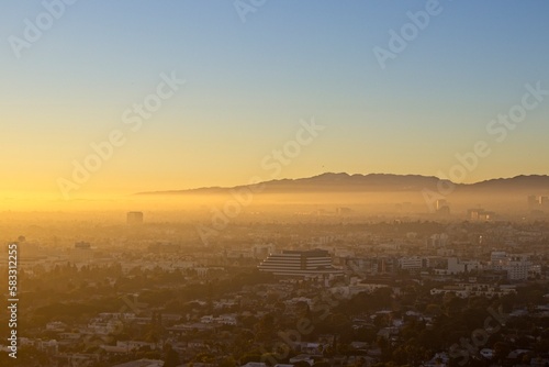 Fog from the ocean rolls over LA's Westside as the sun sets over the Pacific, obscured by the marine layer